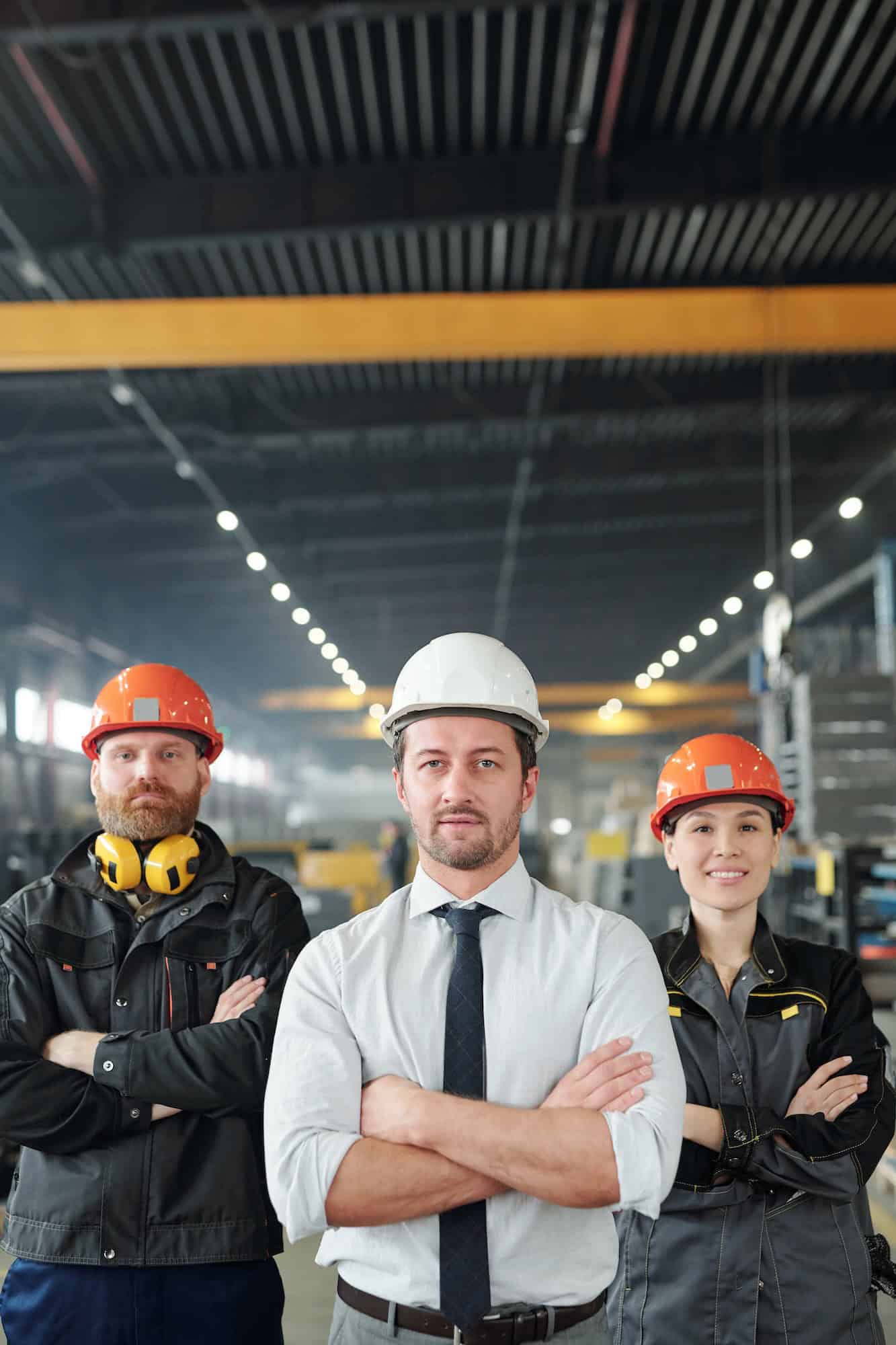 Construction professionals in safety gear inside a factory.